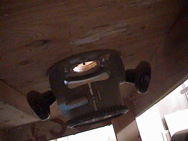 Photo of the underside of a router table showing the router attached.